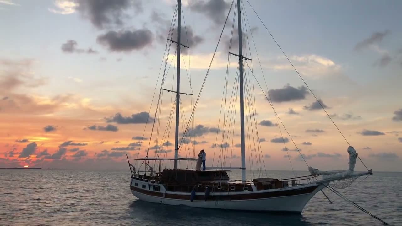 Sailboat at golden sunset on calm water